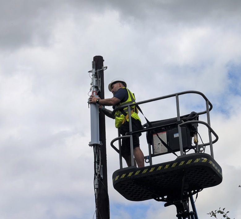 A Wifinity engineer fitting a 5G small cell to a pole